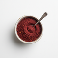 Sumac powder in a ceramic bowl on white background