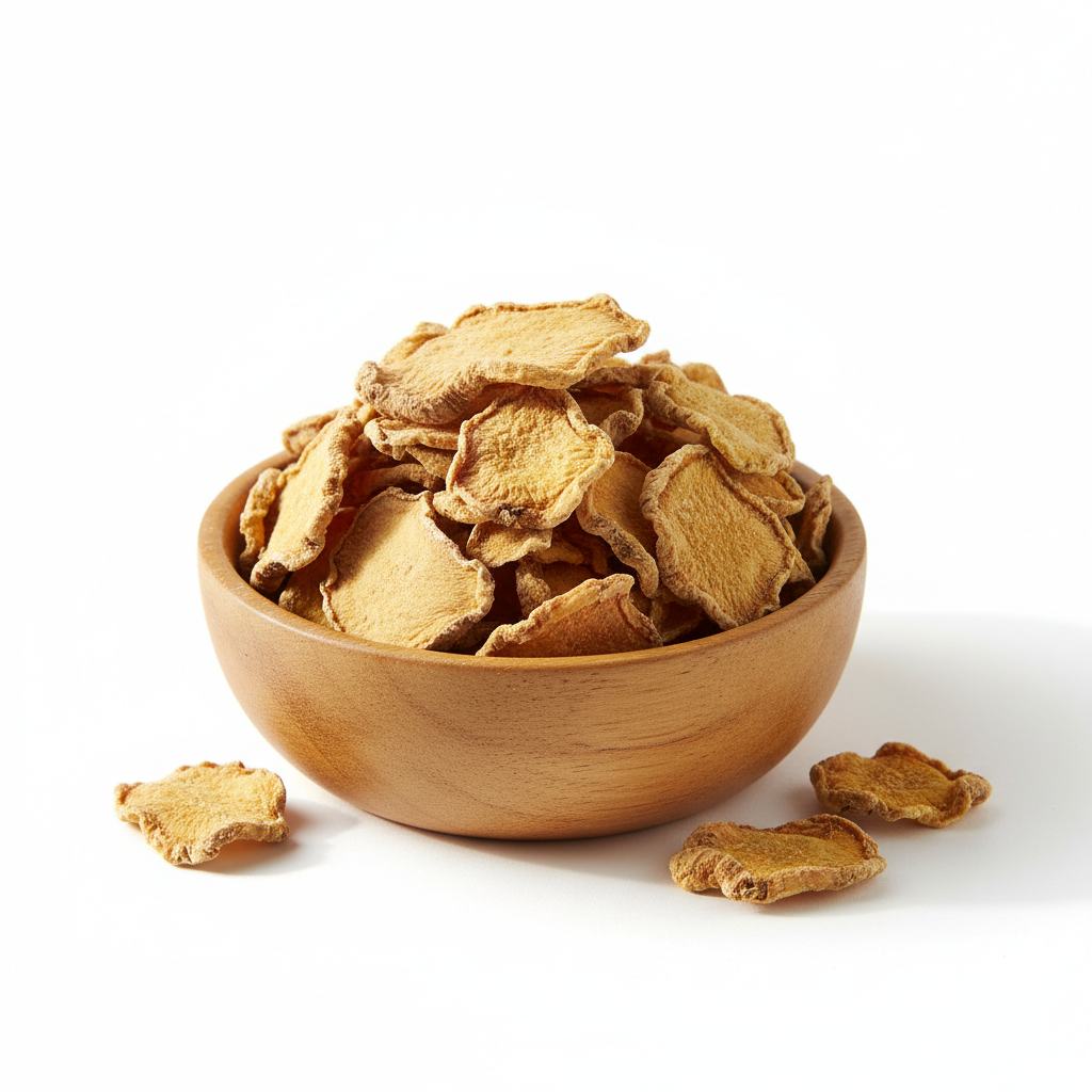 Dried ginger root slices in a wooden bowl on white background