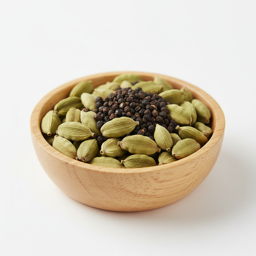 Green cardamom pods and seeds in a wooden bowl on white background
