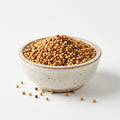 Mustard seeds in a ceramic bowl on white background