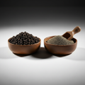 Whole black peppercorns and ground black pepper in wooden bowls on white background