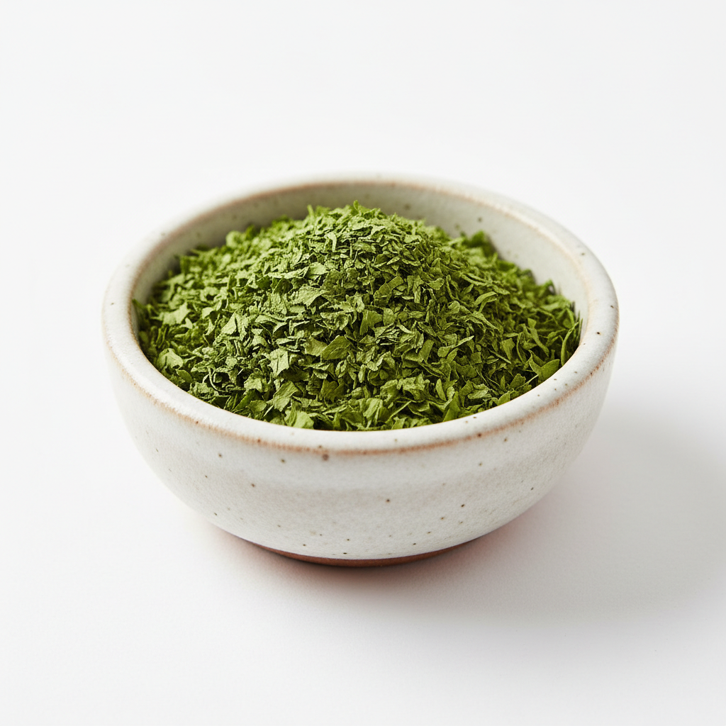 Dried parsley flakes in a ceramic bowl on white background